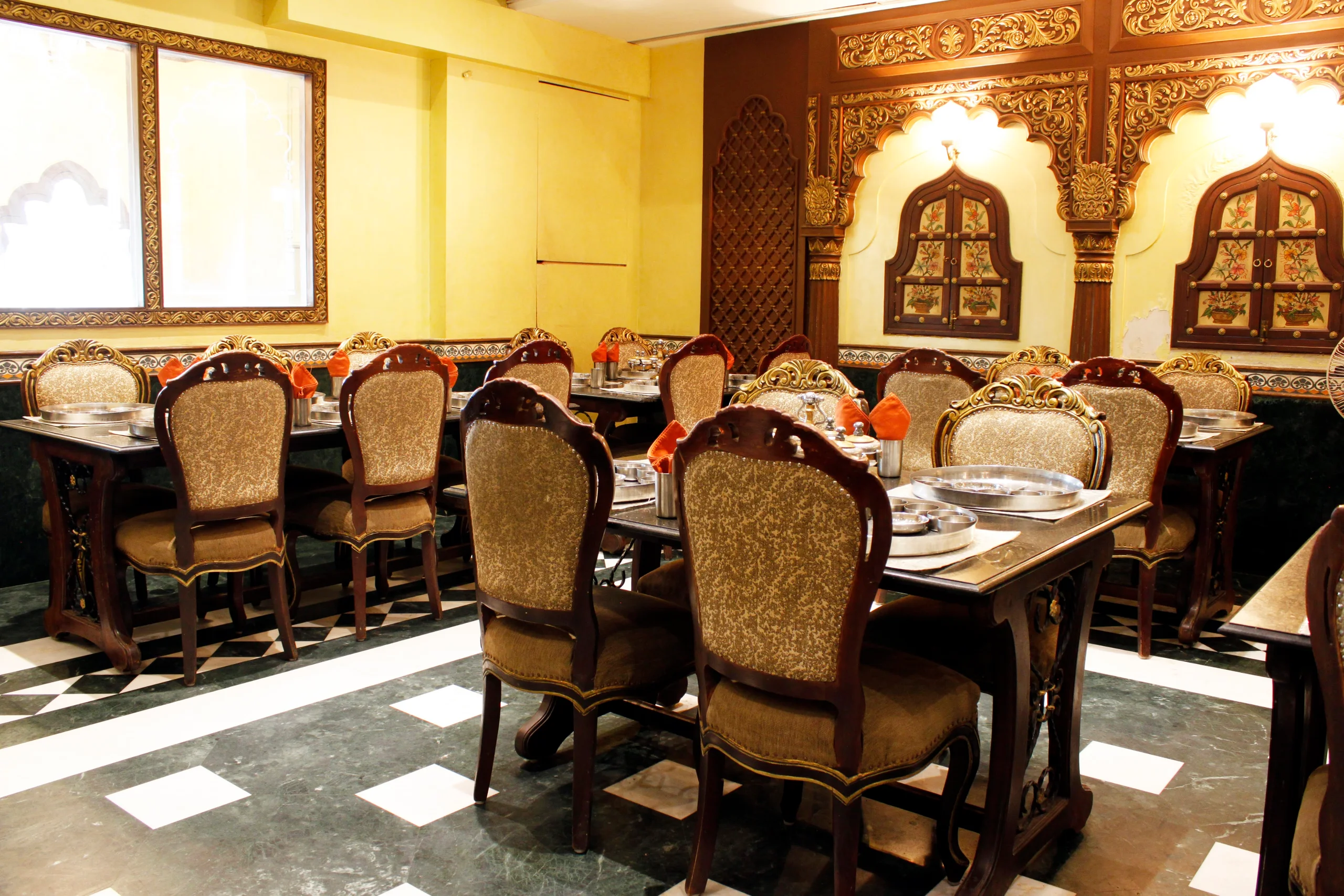 Carved wooden interior and laid thali tables at Gordhan Thal, Bodakdev, Ahmedabad