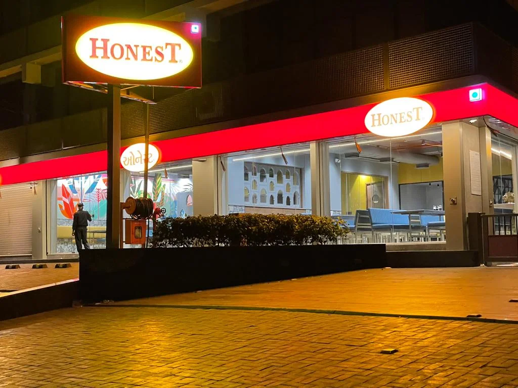 The illuminated Honest Restaurant frontage at night in Navrangpura, Ahmedabad